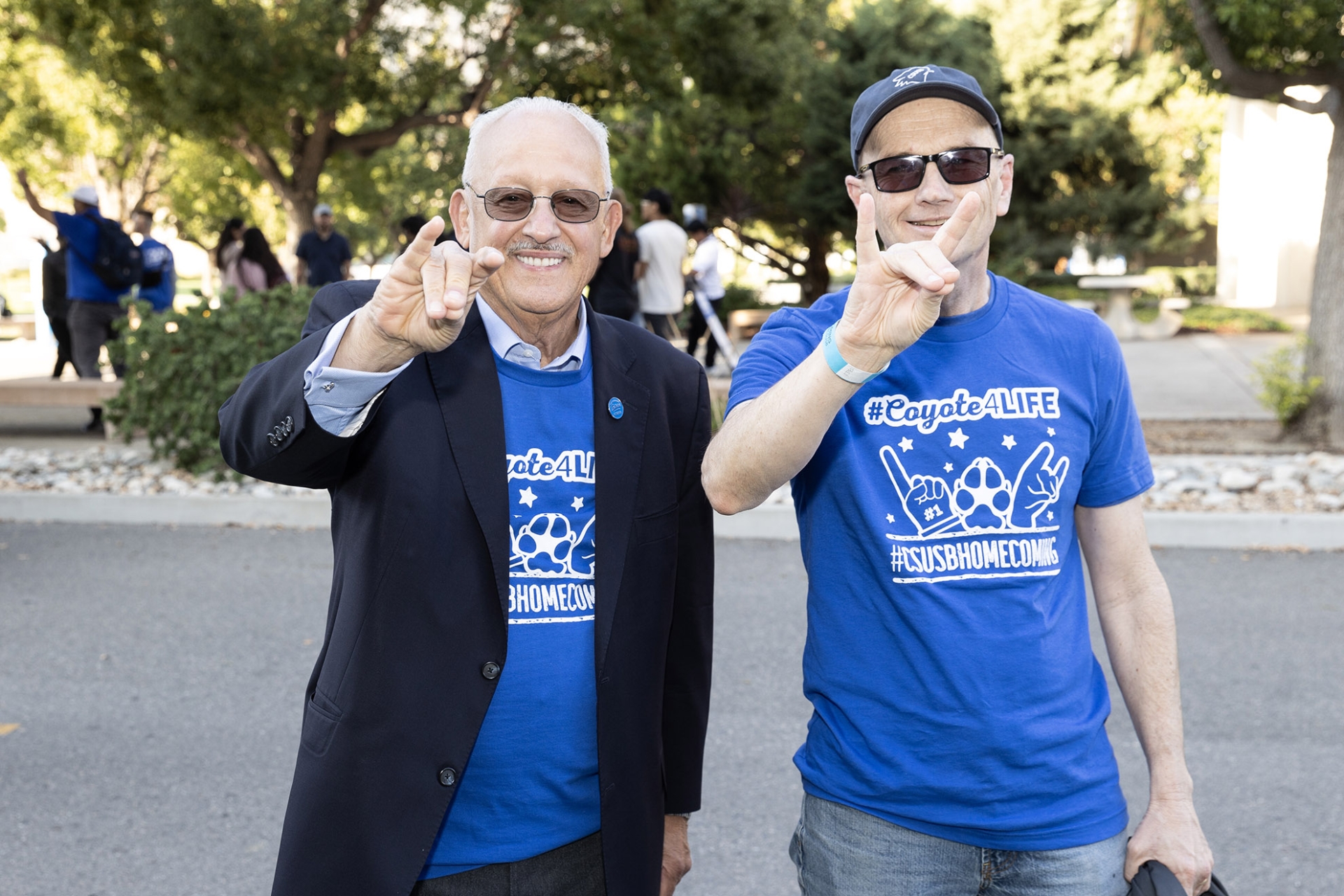 President Tomas D. Morales holds up his Coyote sign 