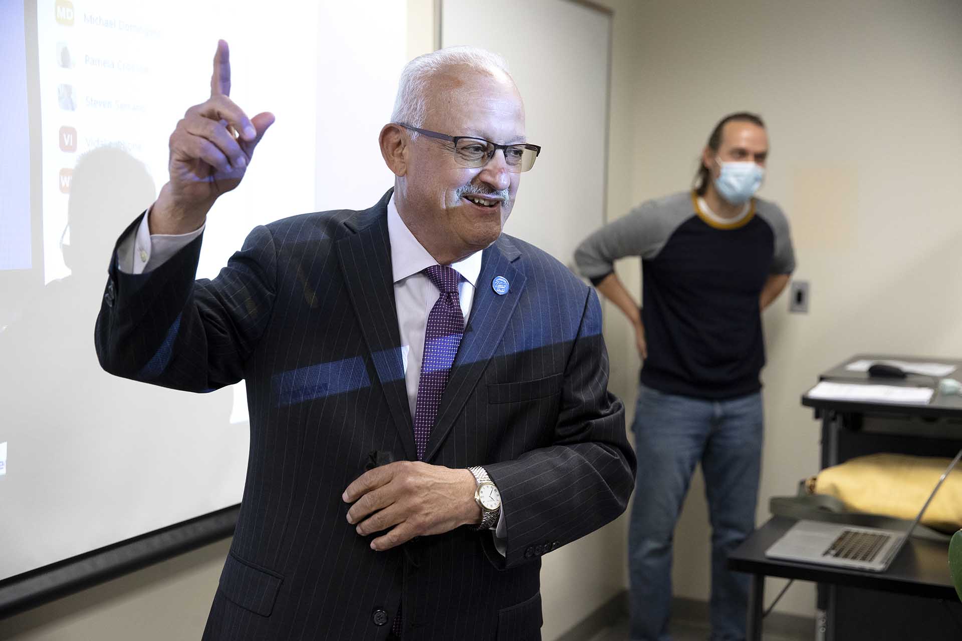 CSUSB President Tomás D. Morales (left) announces to a class that Jeremy Murray associate professor of history, is the 2022 Outstanding Faculty Advisor.