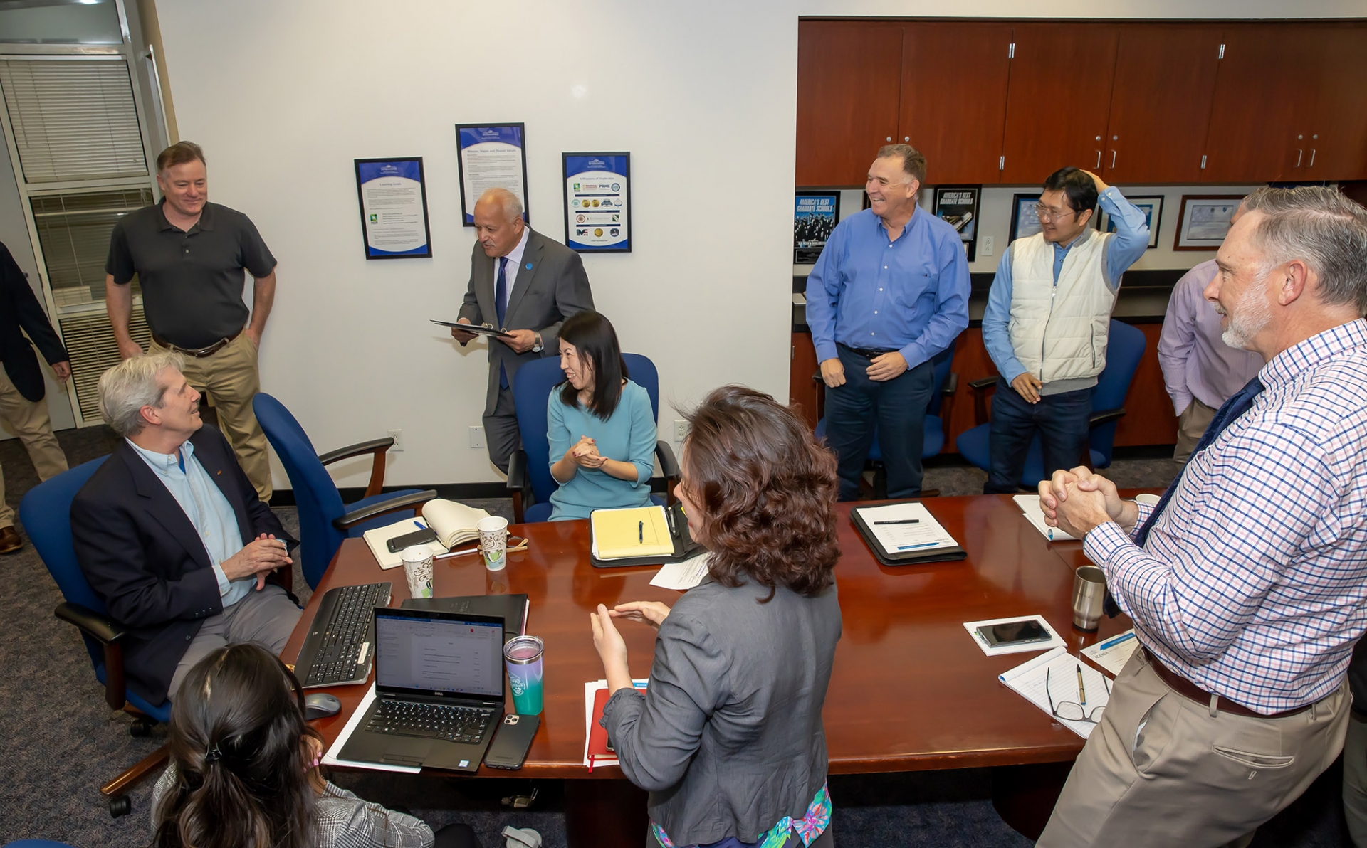 Montgomery Van Wart (seated at left) listens to CSUSB President Tomás D. Morales announces that Van Wart is the university’s 2022-23 Outstanding Professor Award recipient.>>