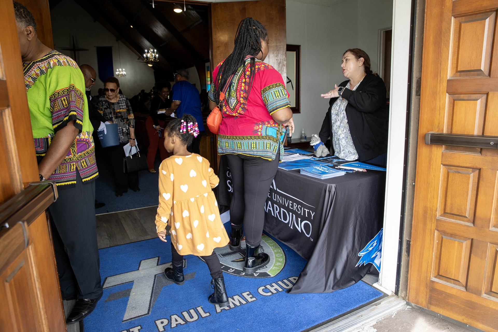 Lucia Zarate (at right) CSUSB Admissions Outreach & Student Recruitment student services professional, meets with a congregant at St. Paul AME Church on Feb. 25 as part of the California State University's Super Sunday.