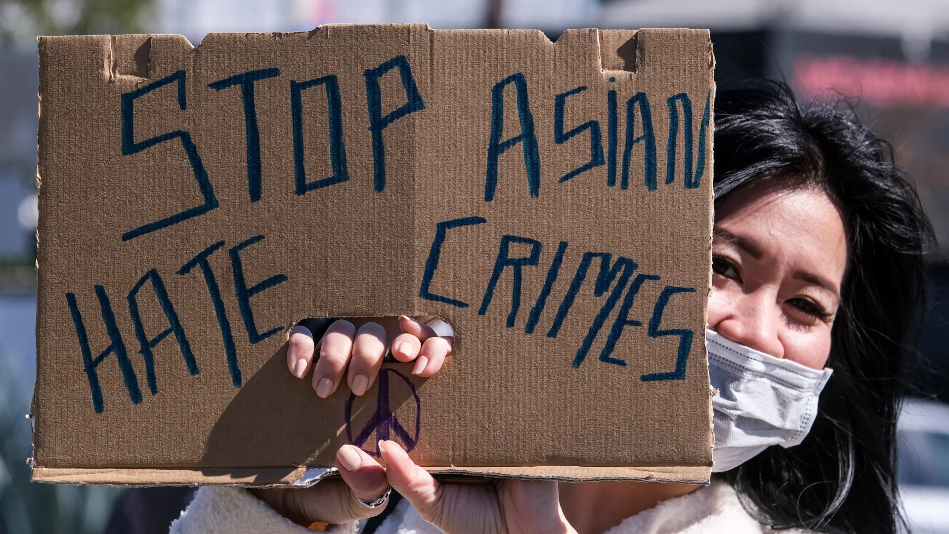 A demonstrator wearing a face mask and holding a sign takes part in a rally in February near LA’s Chinatown.