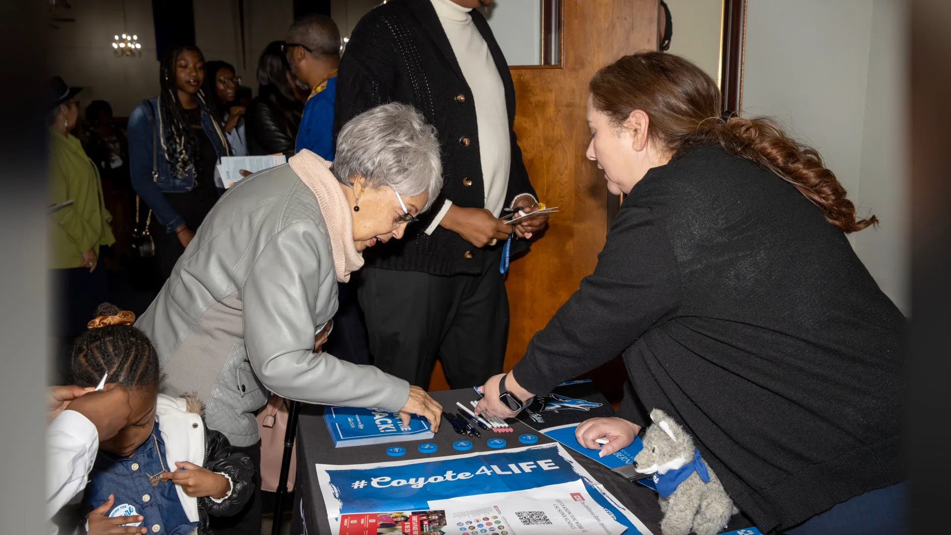 Lucia Zarate (right), of CSUSB’s Outreach and Student Recruitment team, shares information on the university with a member of St. Paul AME Church at the 2024 Super Sunday outreach. 