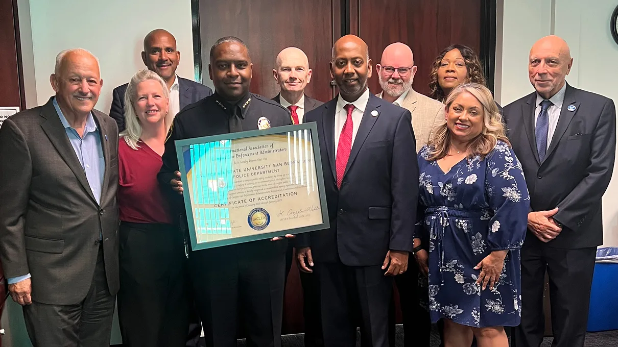 CSUSB Police Chief John Guttierez, surrounded by university administrators, holds a plaque from the  International Association of Campus Law Enforcement Administrators that officially recognizes that the University Police Department has been accredited.