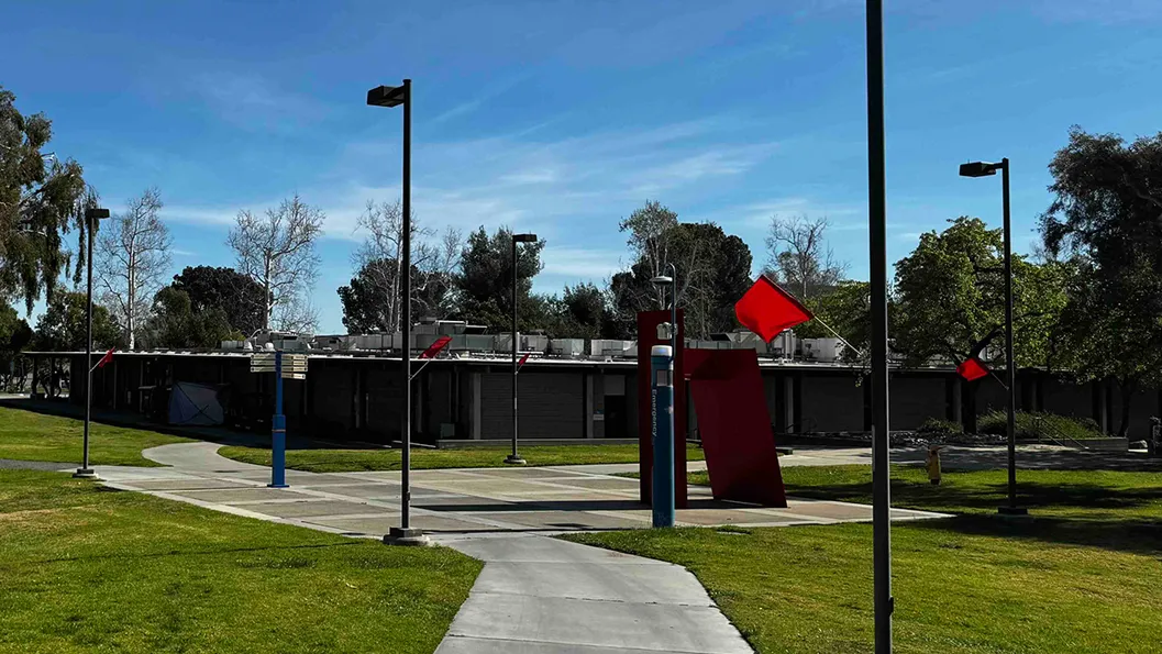 Red flags are displayed across the CSUSB campus.
