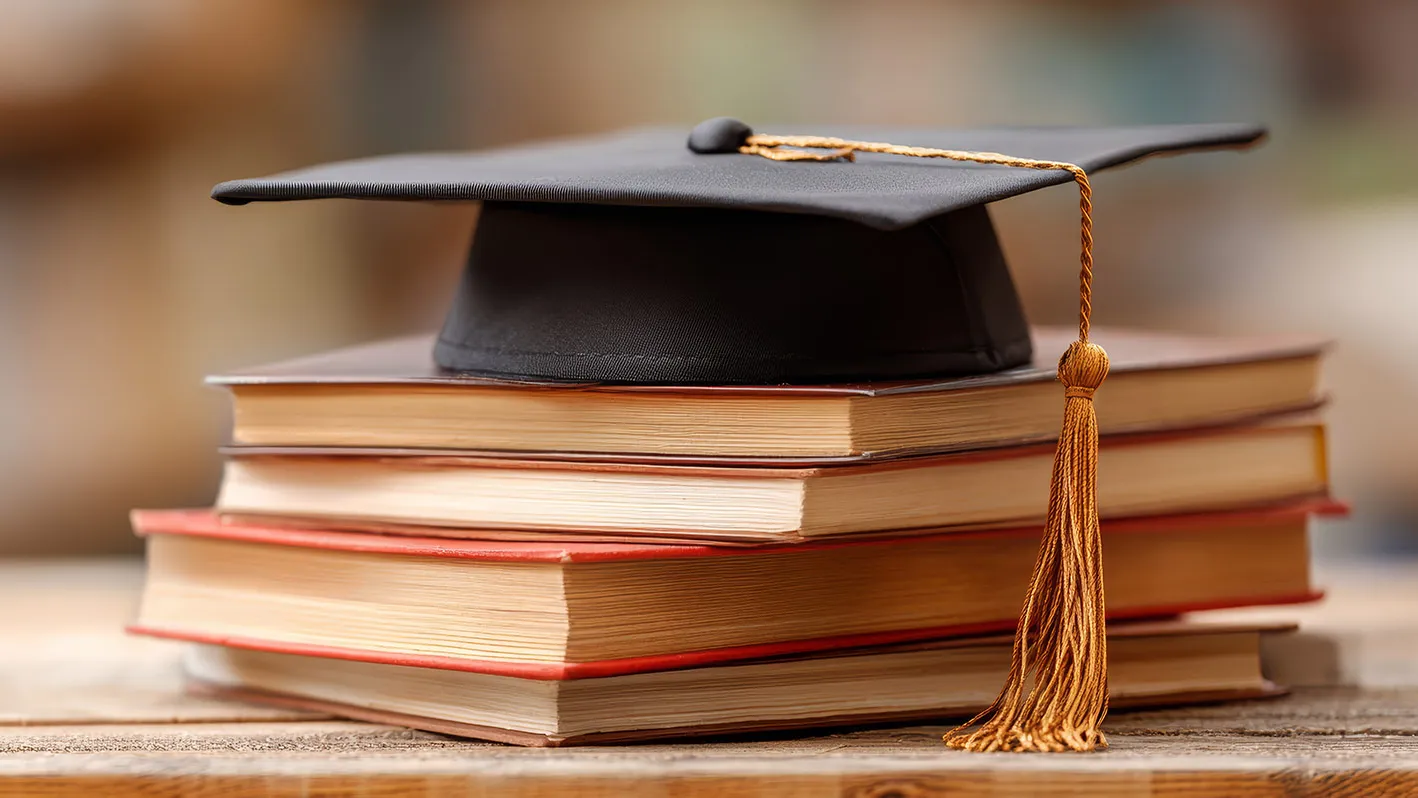 Mortar board and books as symbols of academia.