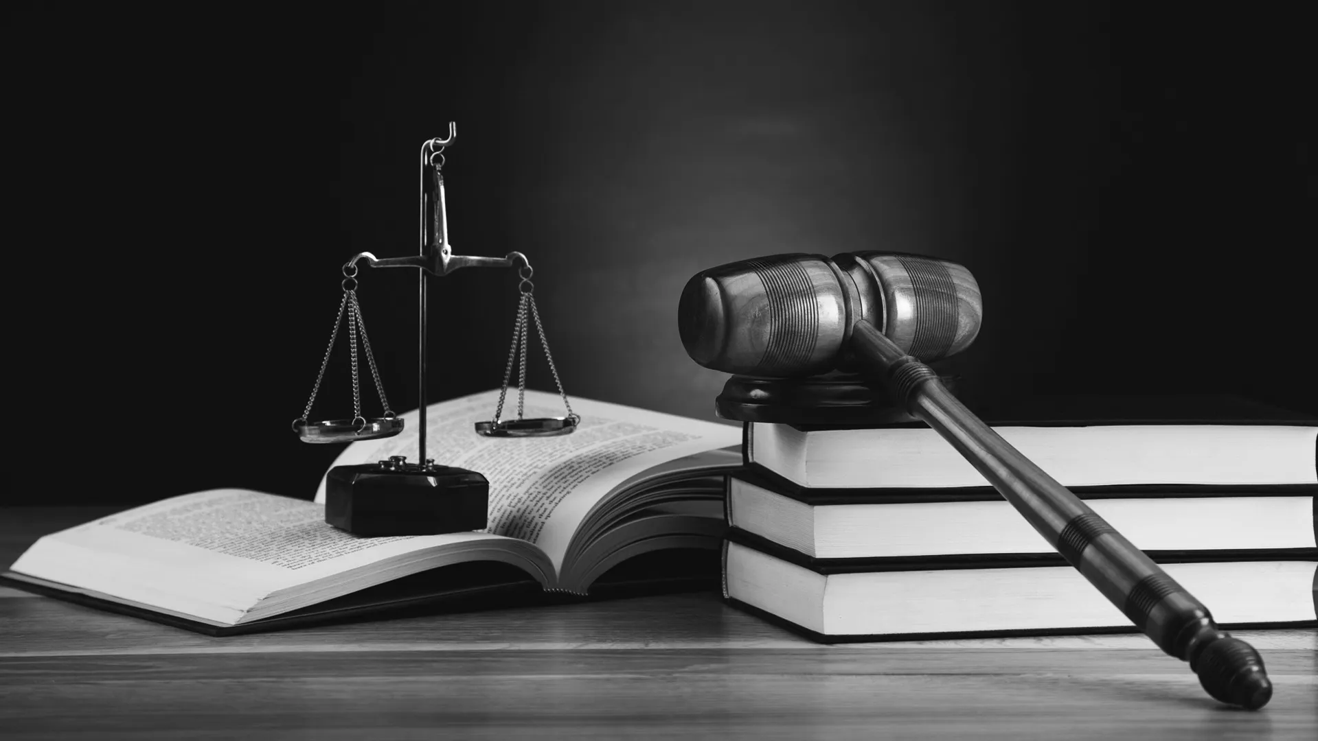 Black and white photo of a scale, books and gavel to symbolize criminal justice