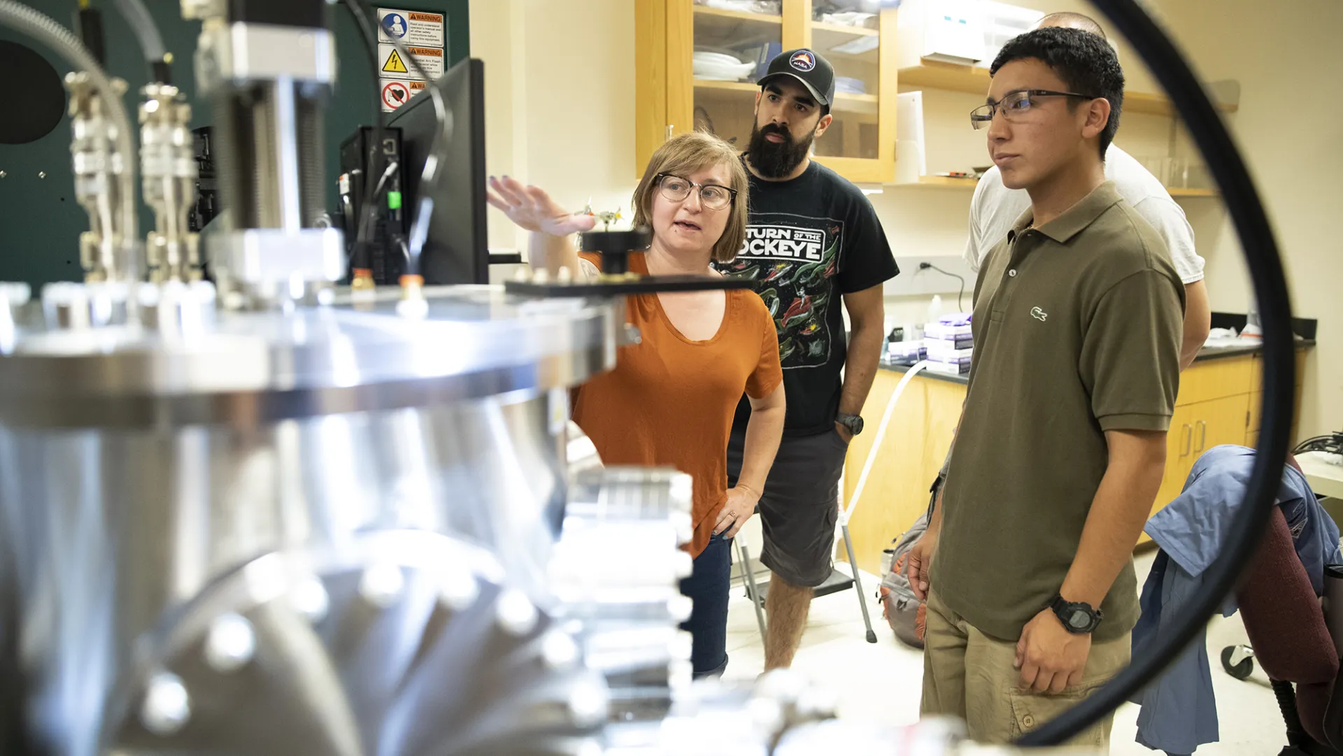 Sara Callori, assistant professor of physics, works with students in a CSUSB lab.