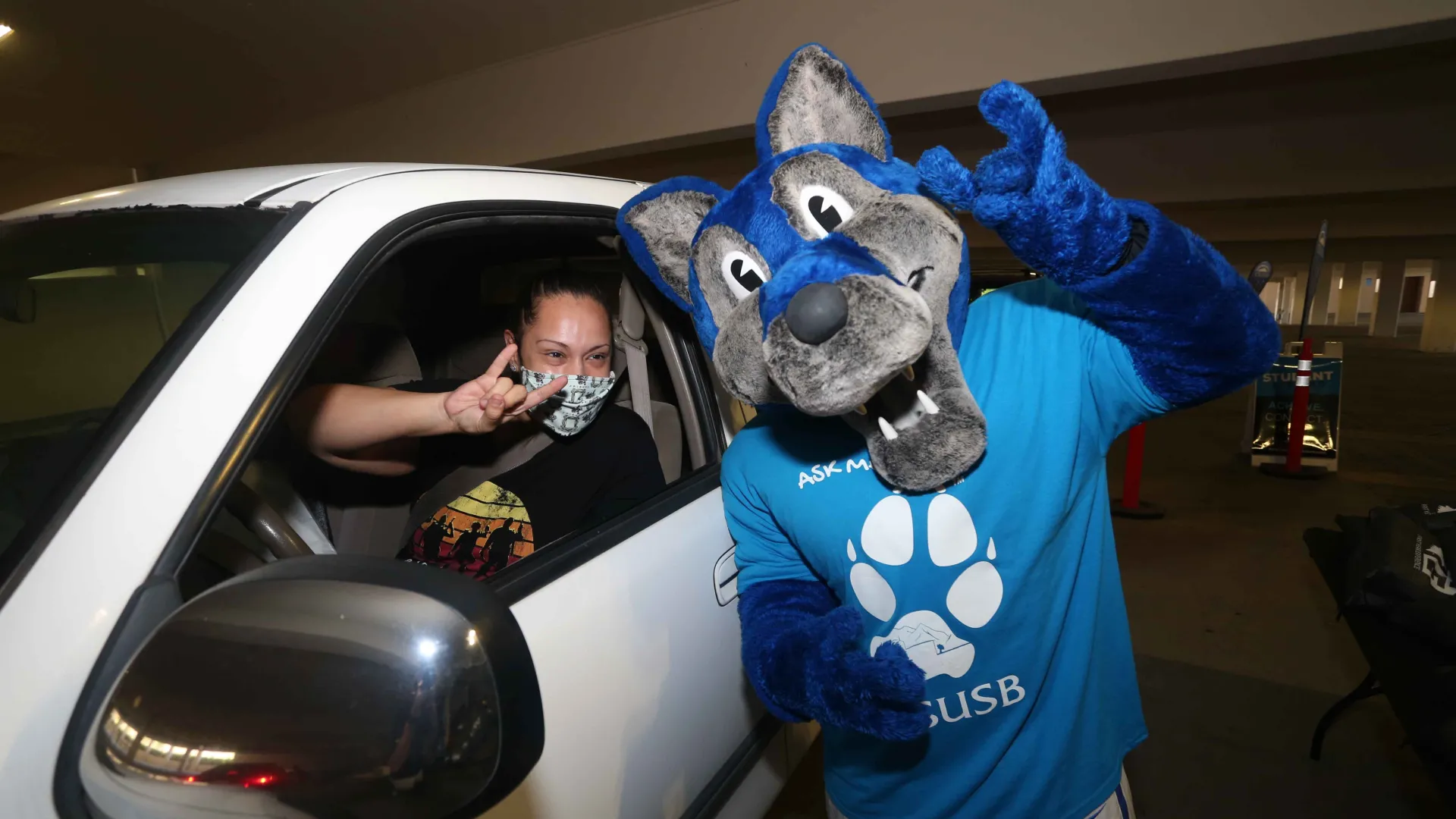 Cody Coyote, CSUSB's mascot, and a student at the Ask Me! drive-thru event on Aug. 24, the first day of the fall semester.