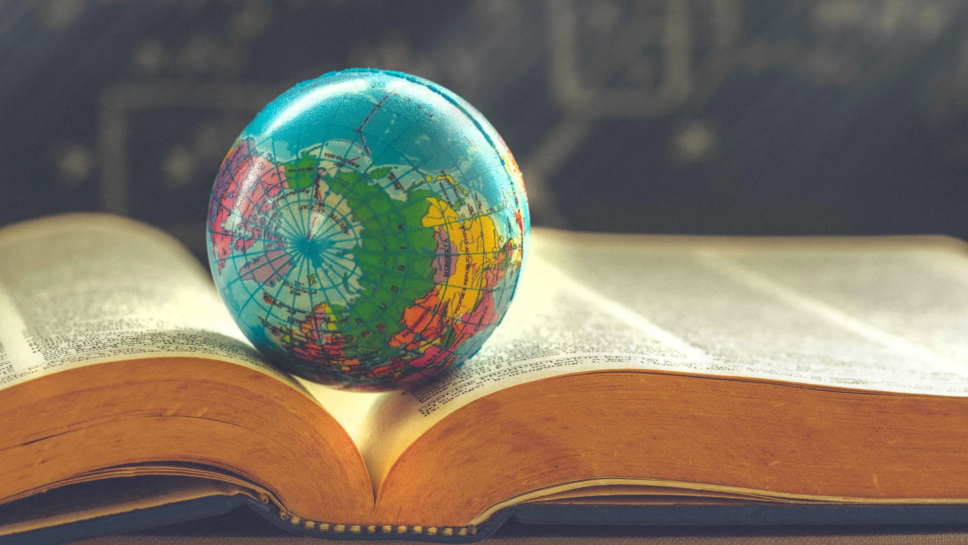 Model globe sitting on an open book.