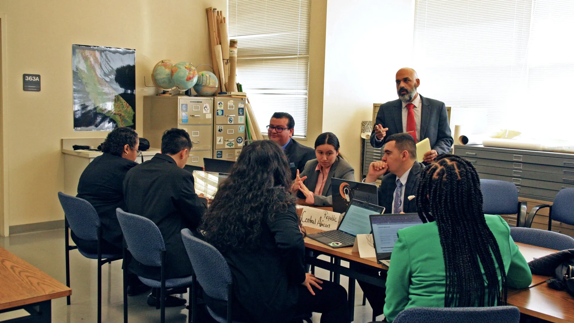 Sina Bastami (standing), director of the CSUSB Model UN program, gives student delegates some pointers as they prepared for the National United Nations Conference, which takes place in New York City April 10-14.