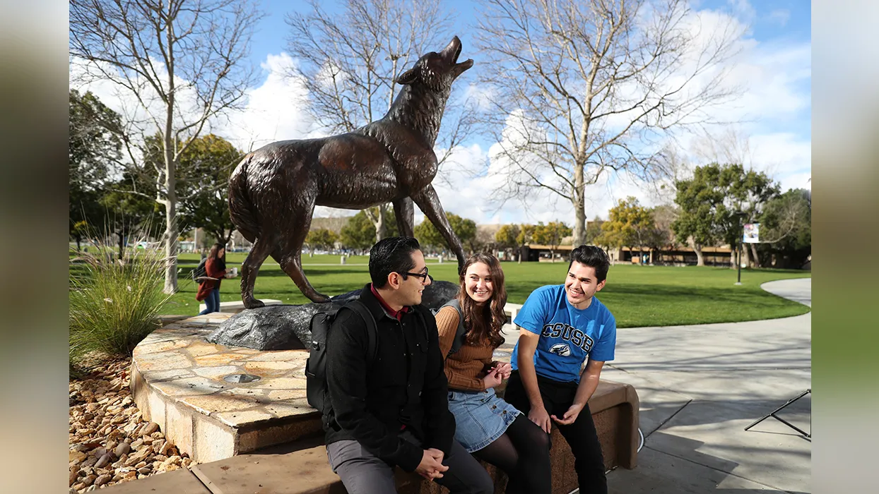 Three students sitting and chatting next to Wild Song