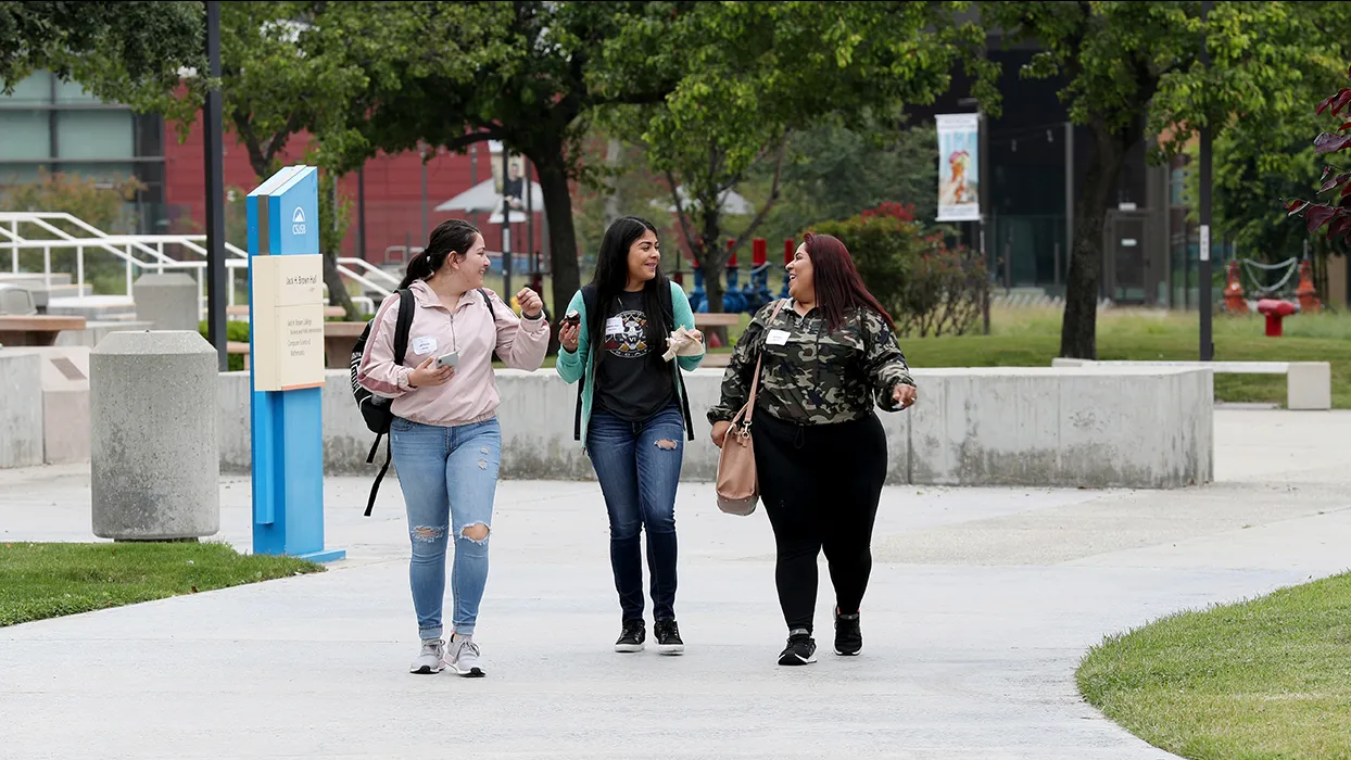 Three students walking on campus