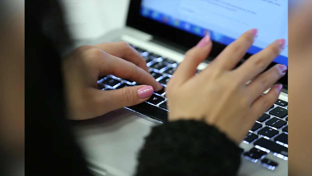 Hands typing on a laptop