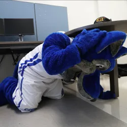 Cody Coyote shows how to drop, cover, hold during a past Great ShakeOut earthquake drill.