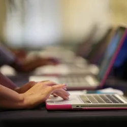 Hands on a laptop keyboard.