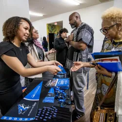 Justus Baker-Postell (left), a CSUSB student majoring in marketing, shares information about the university with a member of the Immanuel Praise Fellowship in Rancho Cucamonga during the Super Sunday outreach on Feb. 23