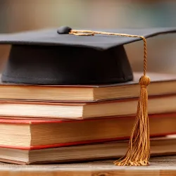 Mortar board and books as symbols of academia.