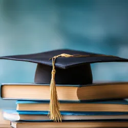 Illustration of a mortar board and books symbolizing academics.