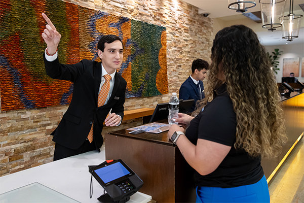 Baldomero Felix, CSUSB alumnus and The Ritz-Carlton Rancho Mirage manager-in-training, assisting a guest.