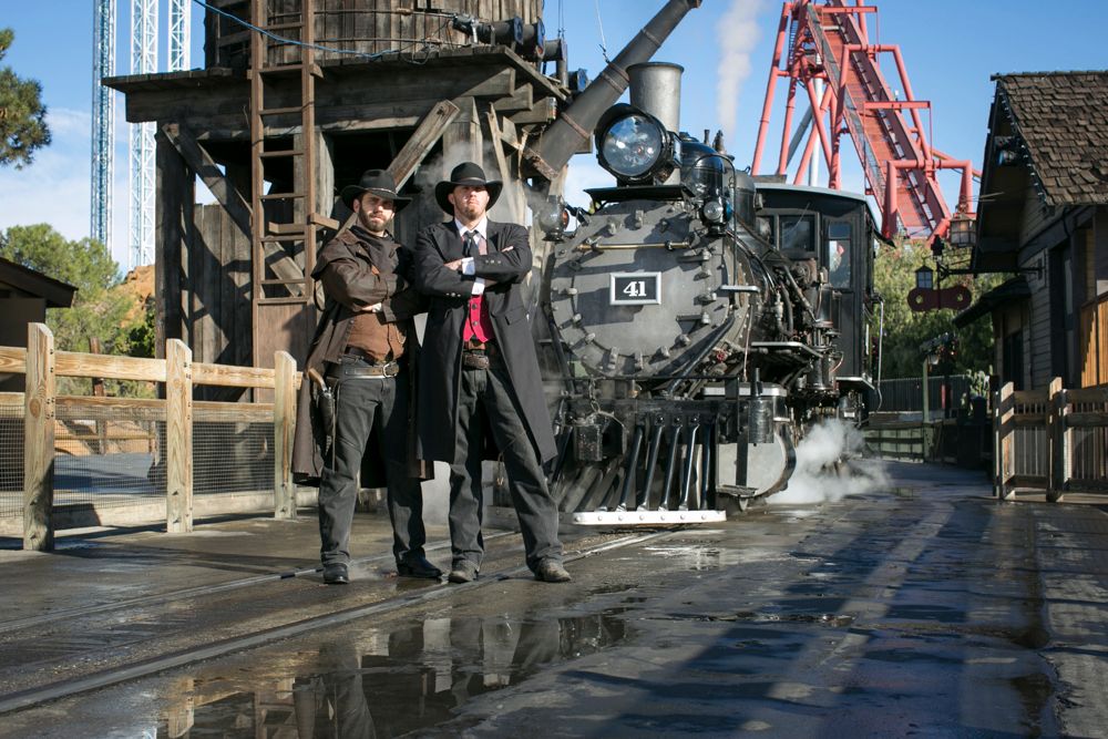 2 wild west mean in front of steam train at Knotts