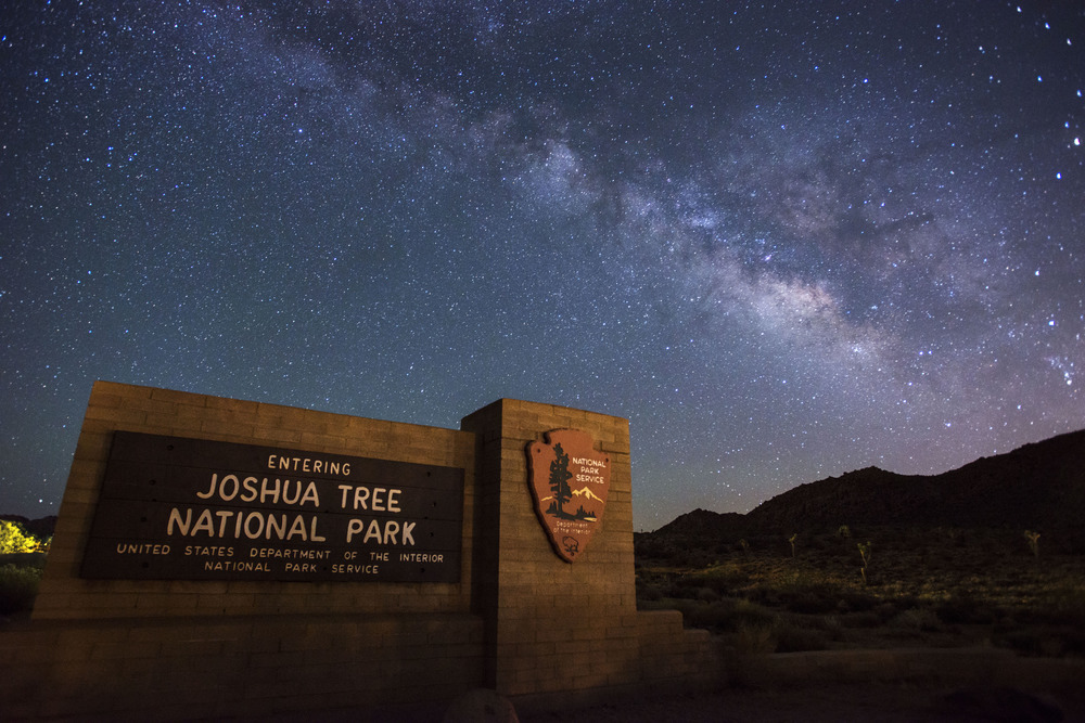 Joshua Tree National Park Sign at night with milky way 