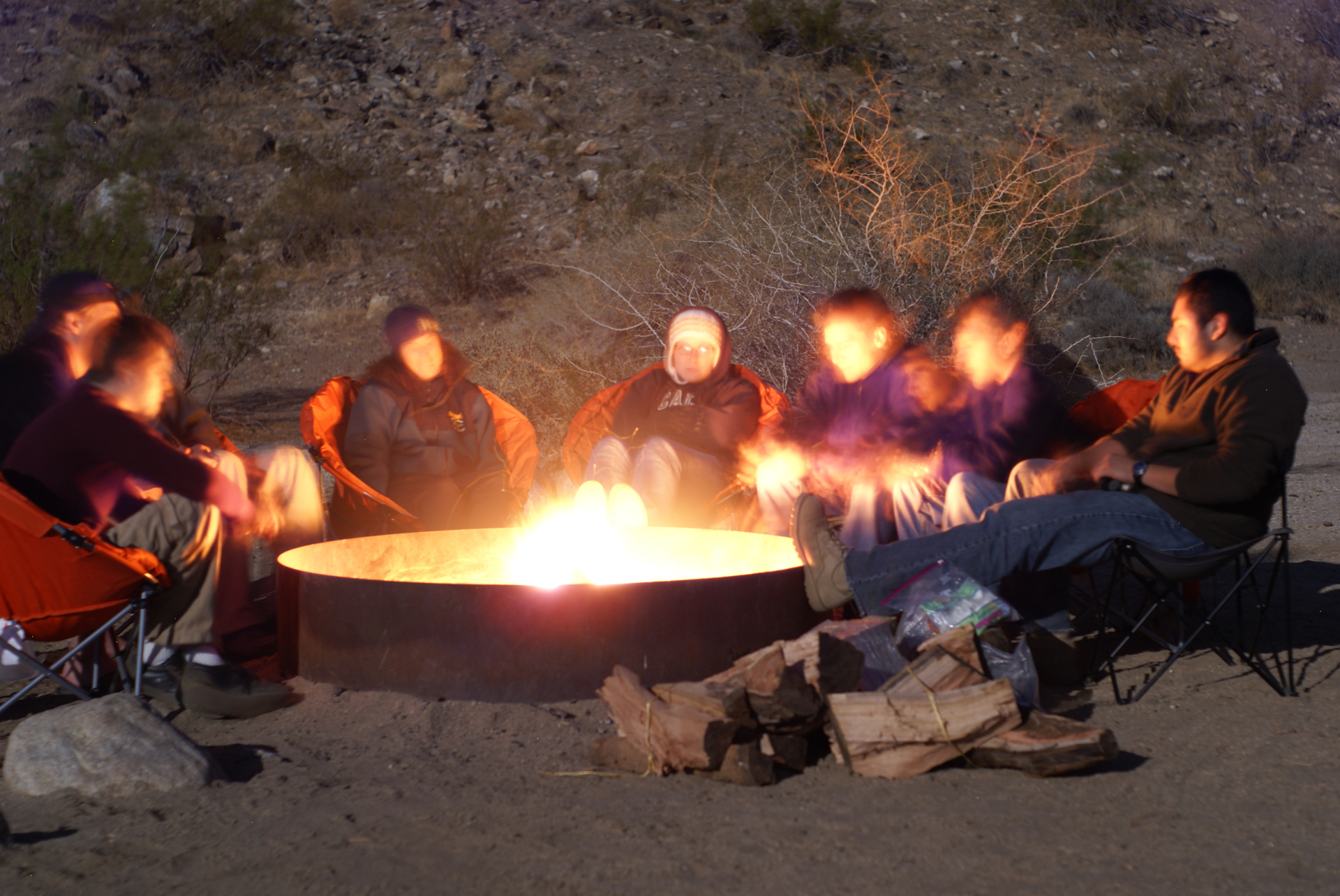 group of students sitting around campfire