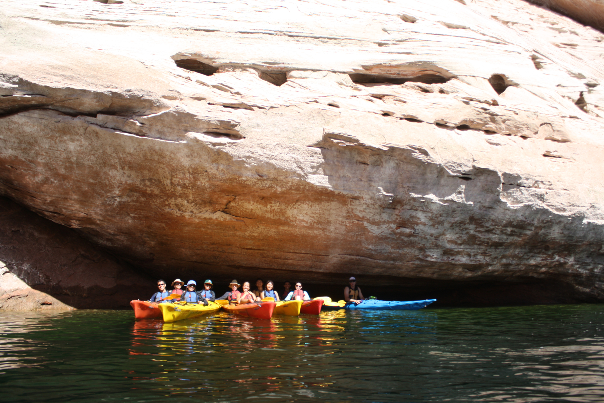group of kayakers in front of rock