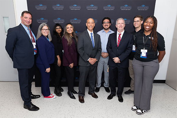 Amy Hysell (second from left) and Tony Coulson (third from right) oversaw the creation and publication of the NCAE-C’s “Executive Edition.” Hysell and Coulson posed with Center for Cyber and AI staff and White House Deputy National Cybersecurity Director Harry Wingo (center with blue tie) at the Oct. 25 Cyber Ecosystem Leadership Forum. From left, Dr. Vincent Nestler, Amy Hysell, Hannah Samy, Vanessa Zaldivar, Harry Wingo, J.D., Cesar Coronado Ramirez, Dr. Tony Coulson, Alex Edsell and Erinea House.