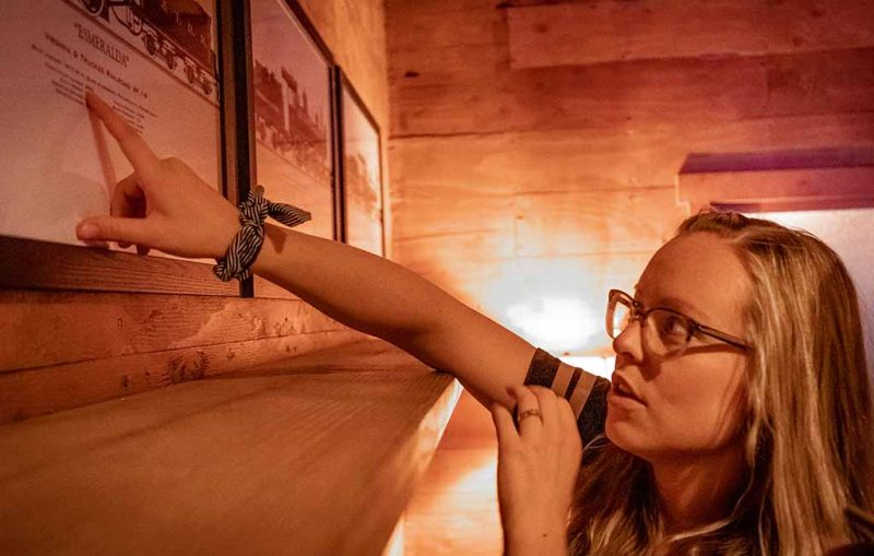 woman pointing at works on picture on wall on cabin