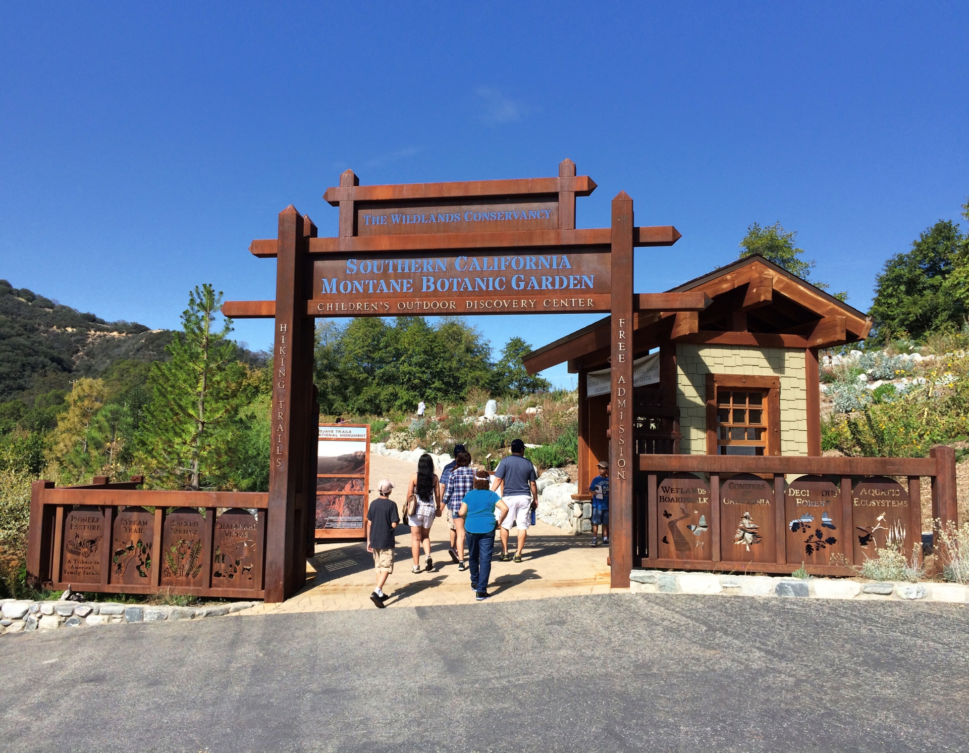 family of 5 walking under meatal botanic garden sign