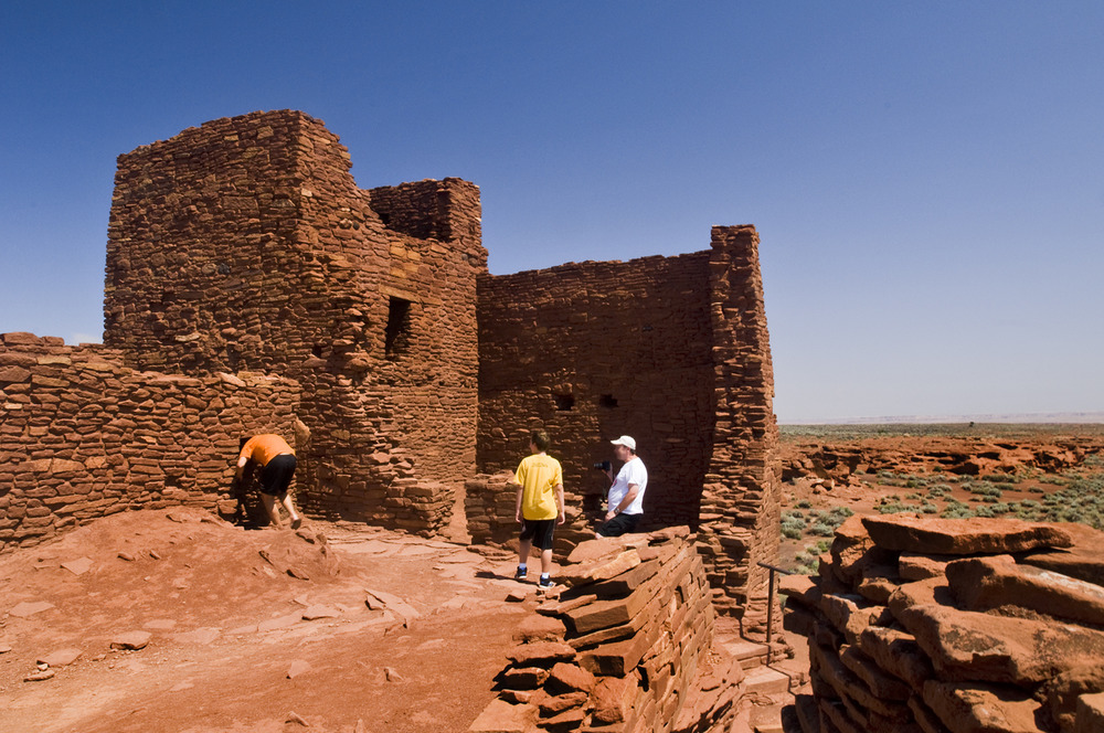 3 students looking at ruins red rocks