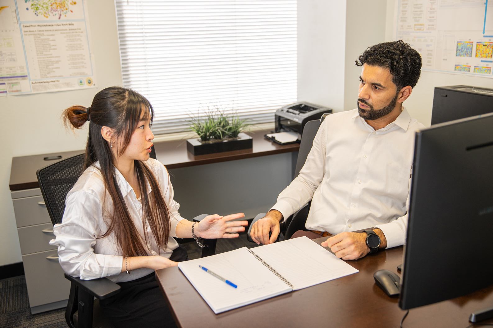 Khan, at right, discusses the water treatment research project with his student, Ha Trinh.
